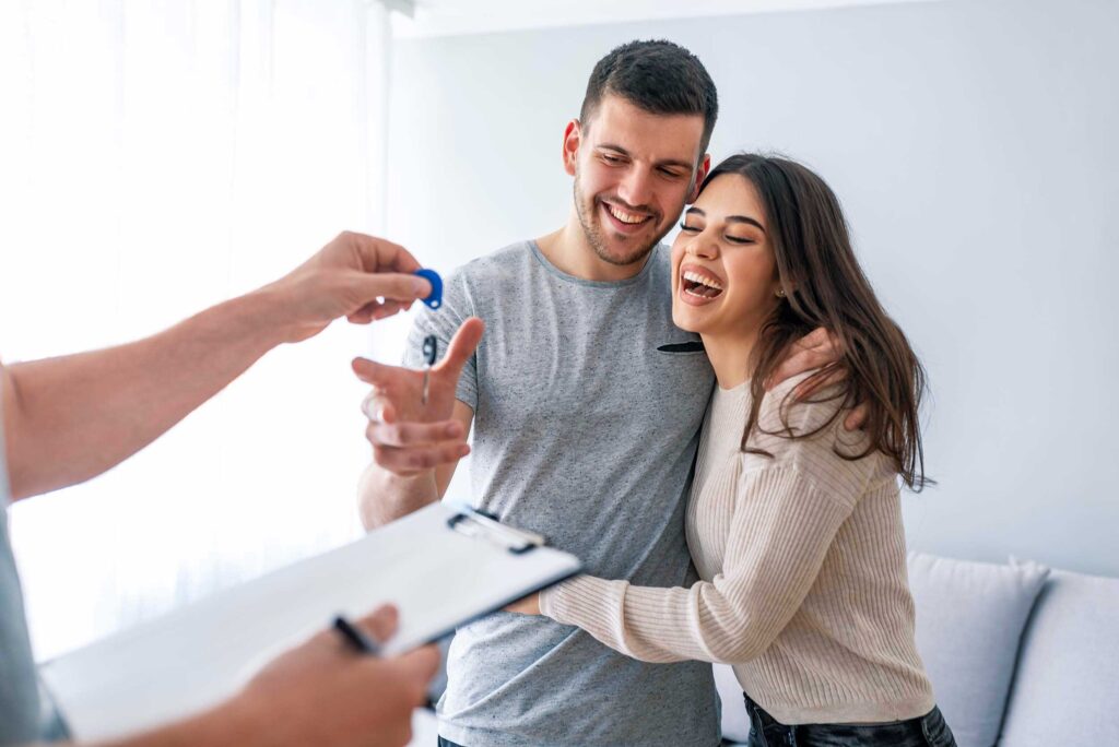 young couple getting keys to their new home
